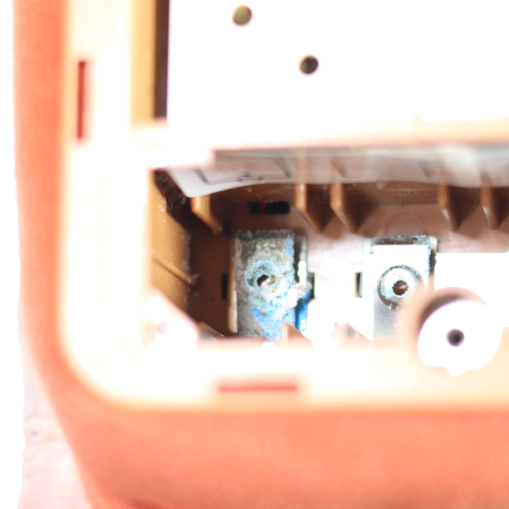 Close-up of a mechanical device inside a pink container