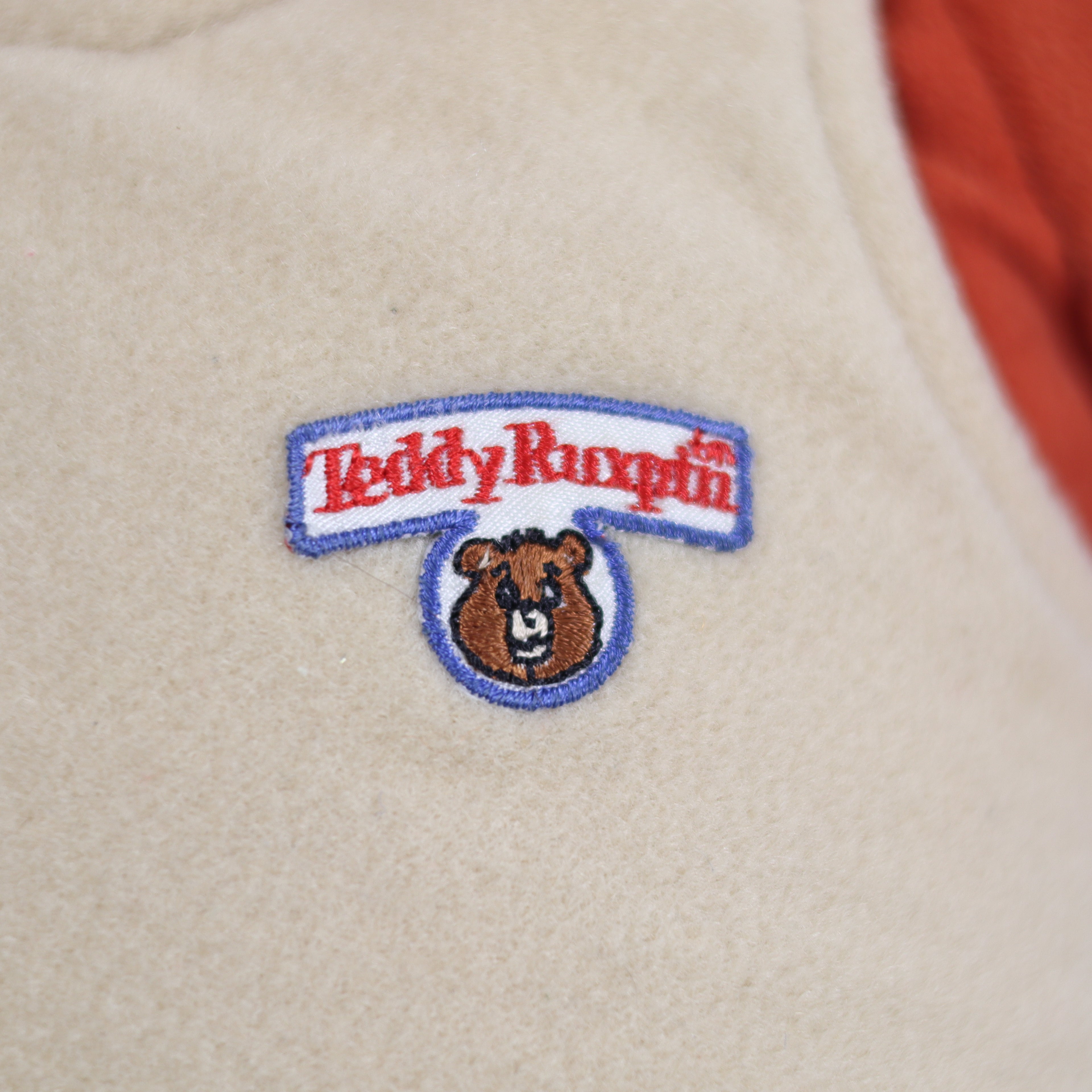 Patch with 'Teddy Ruxpin' logo on a beige background