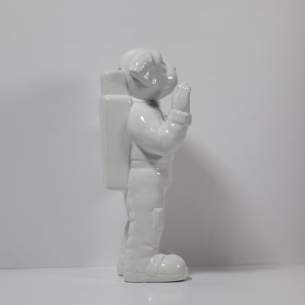 White ceramic figure of an astronaut on a plain background