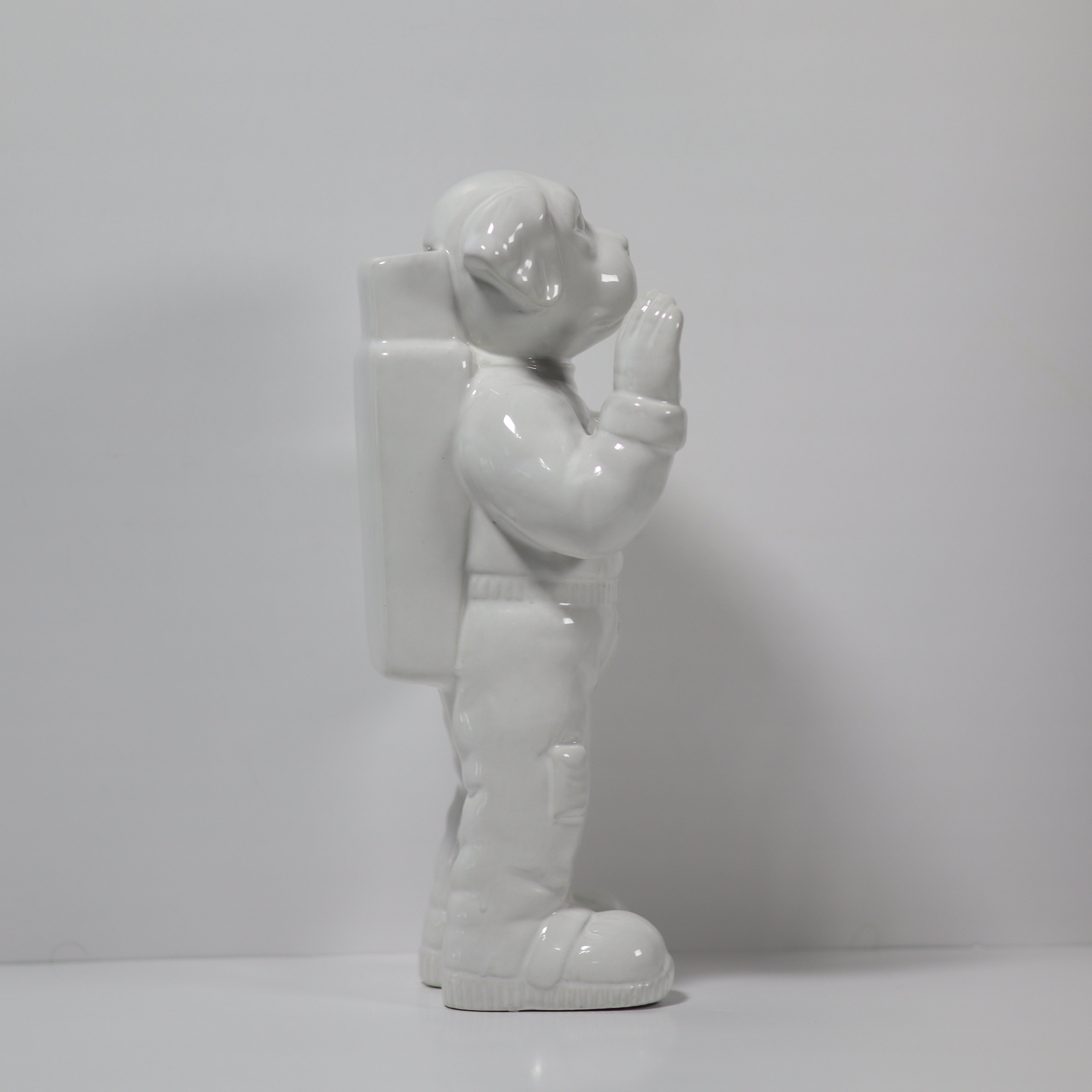 White ceramic figure of an astronaut on a plain background