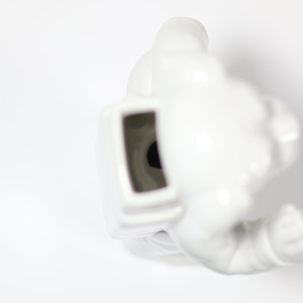 Close-up of a white electronic device with a black component on a light gray background