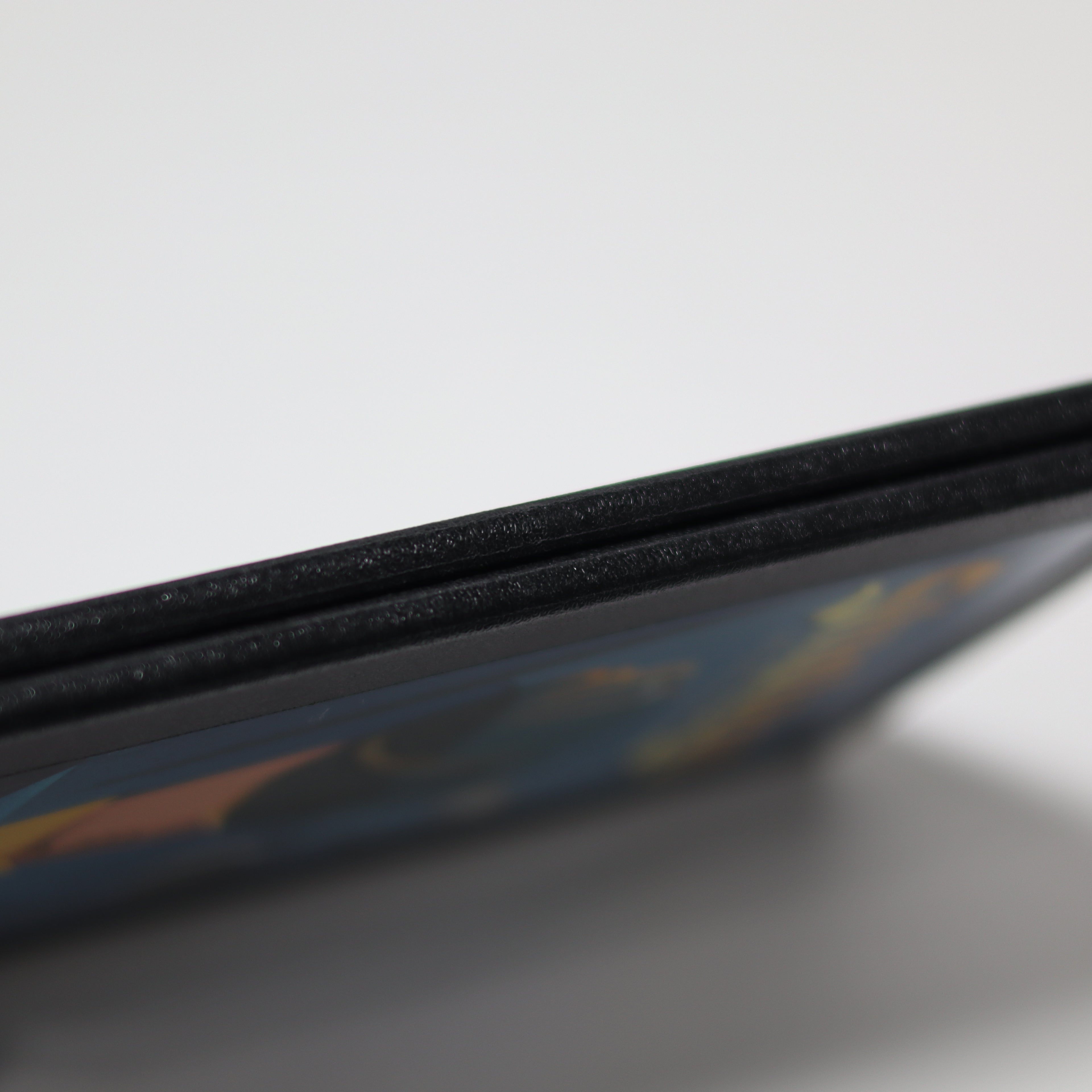 Close-up of a gameboard edge on a reflective surface with a blurred background