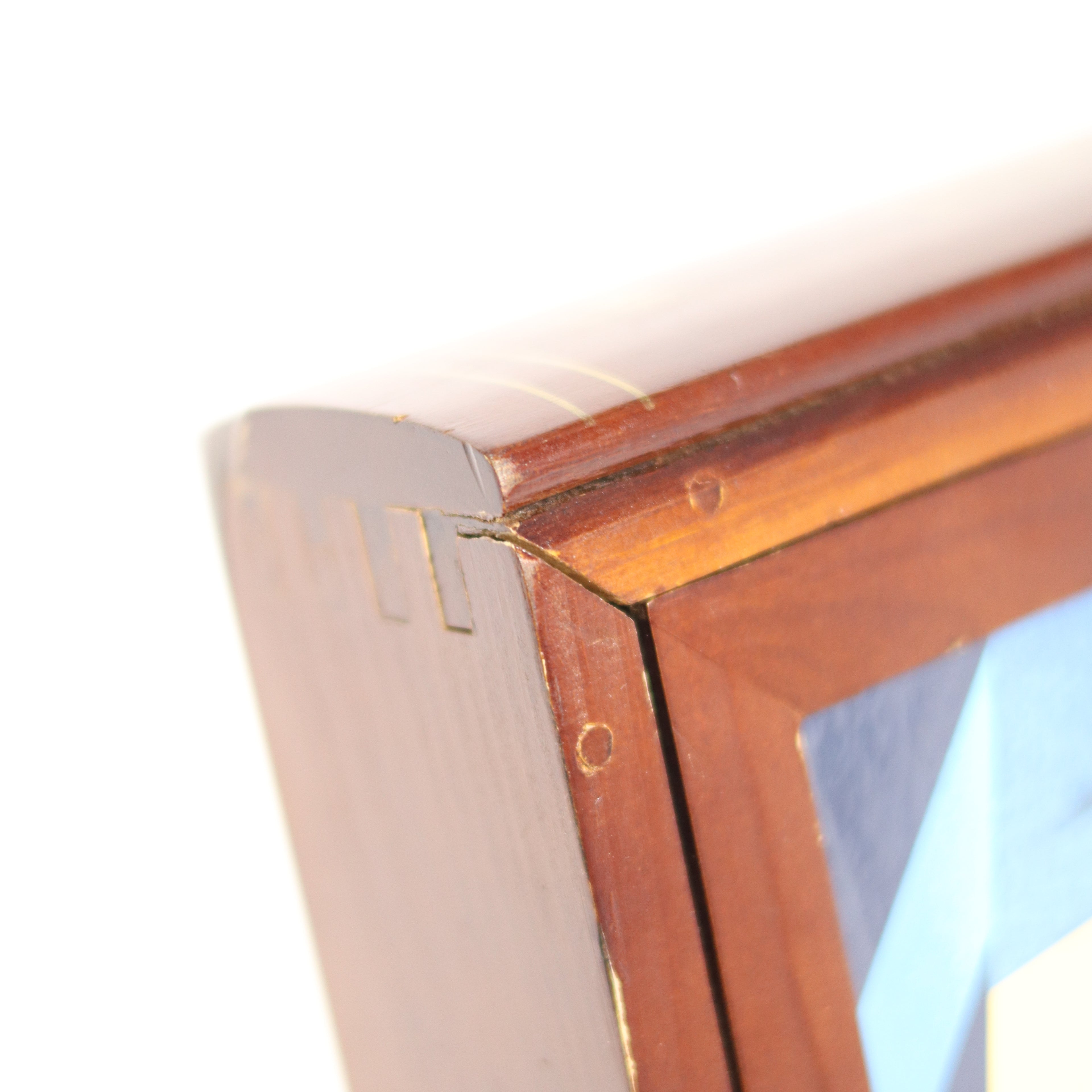 Close-up of a wooden picture frame corner with a white background