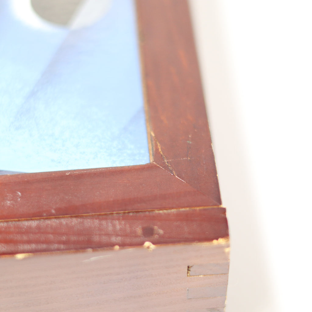 Close-up of a wooden picture frame with a blurred background