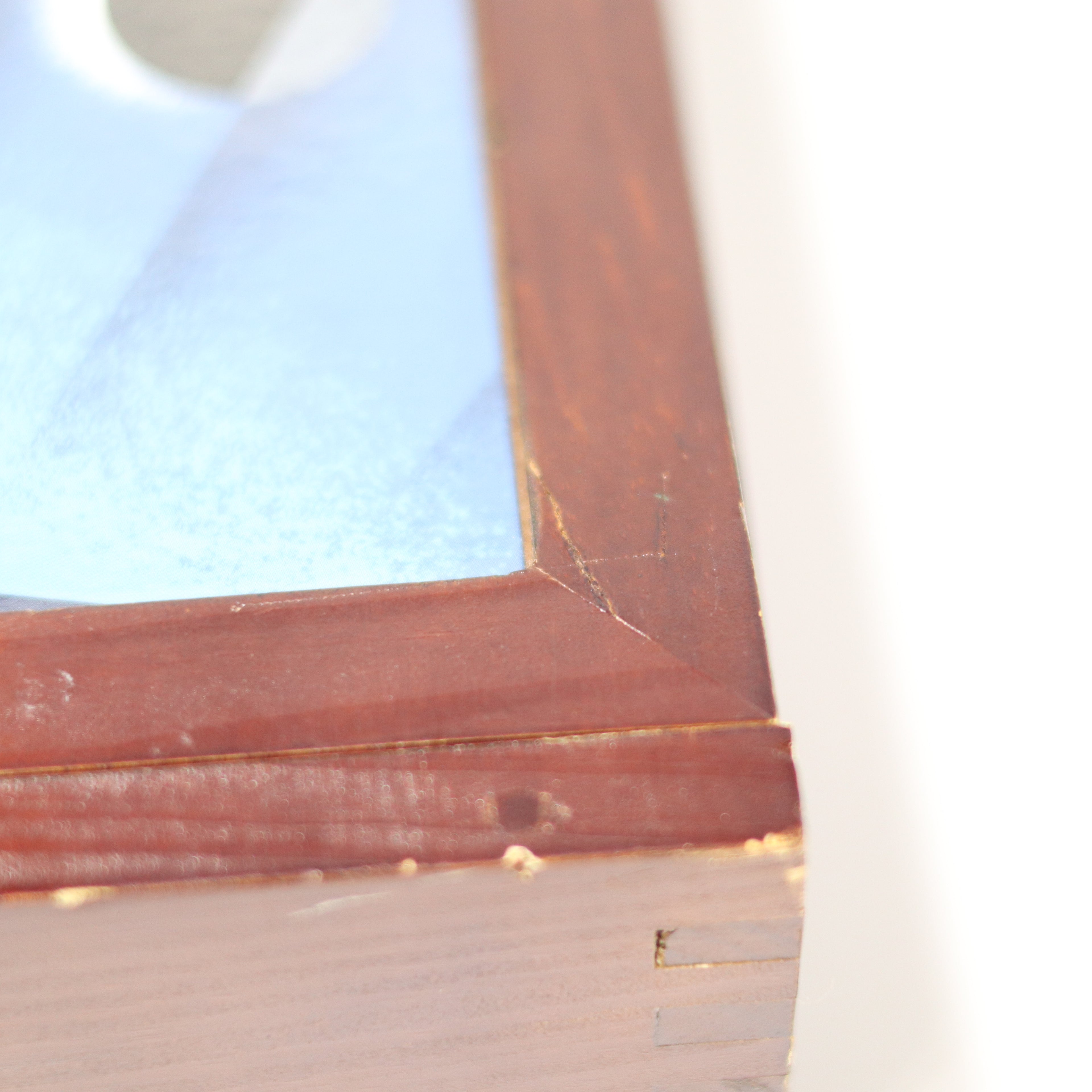 Close-up of a wooden picture frame with a blurred background