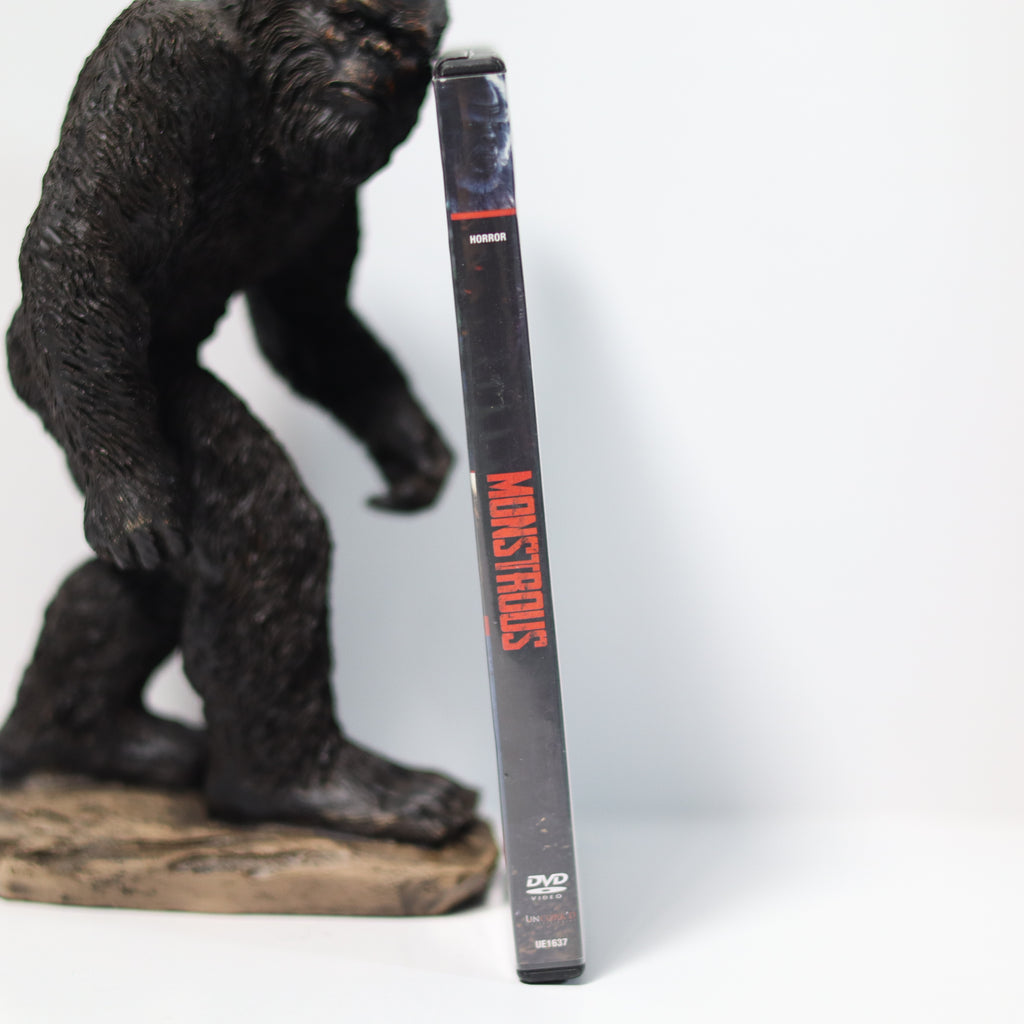 Gorilla figurine next to a DVD case with 'Monsters' branding on a white background
