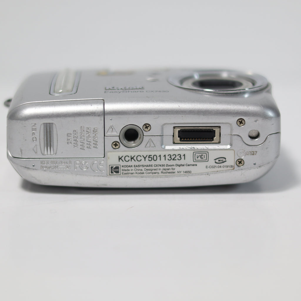 Back view of a silver digital camera on a white background