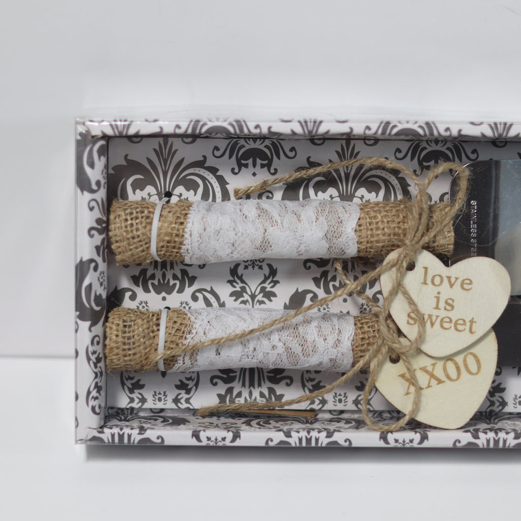 Decorative gift set with lace rolls and a heart-shaped tag on a patterned box.