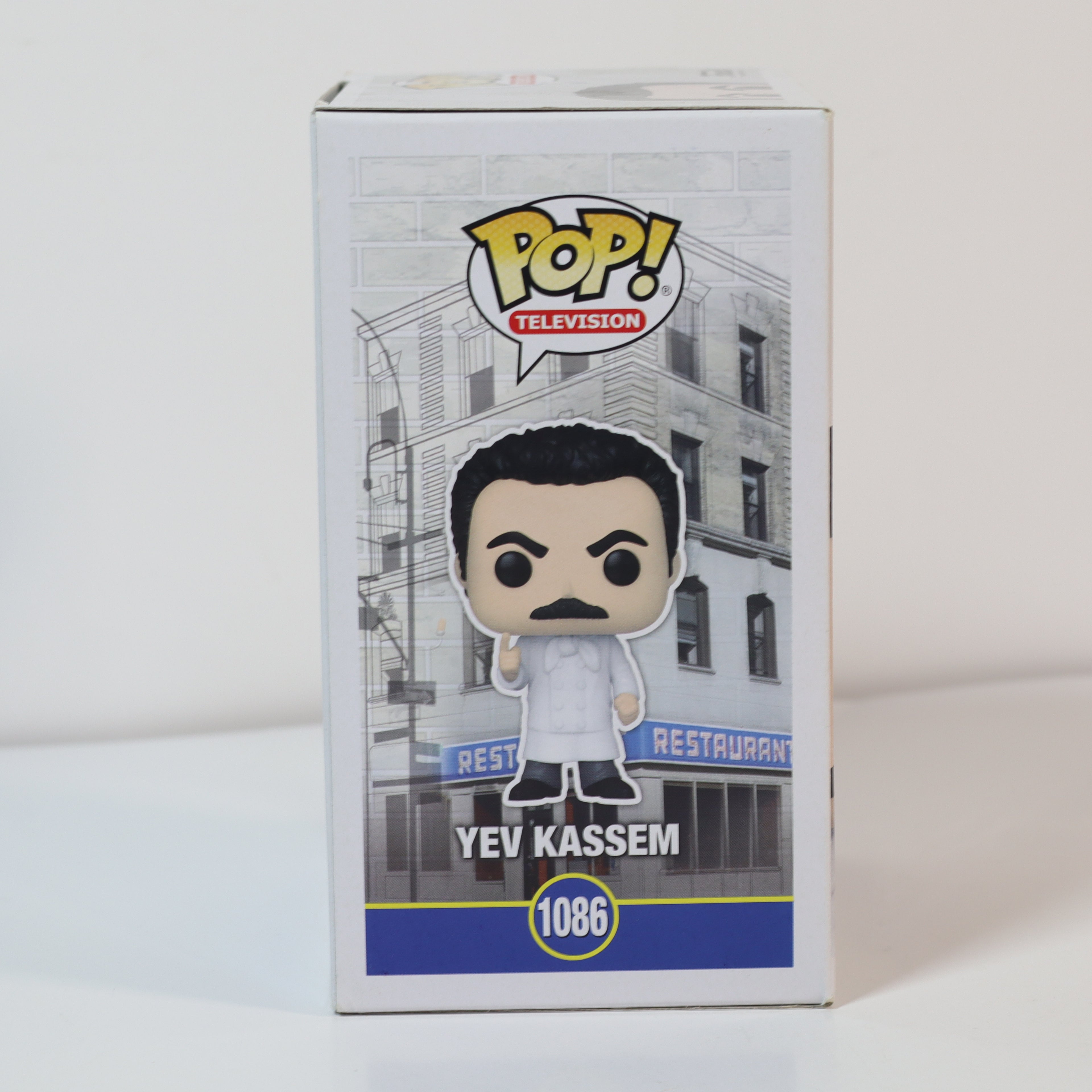 Funko Pop! vinyl figure packaging with a building and restaurant sign in the background