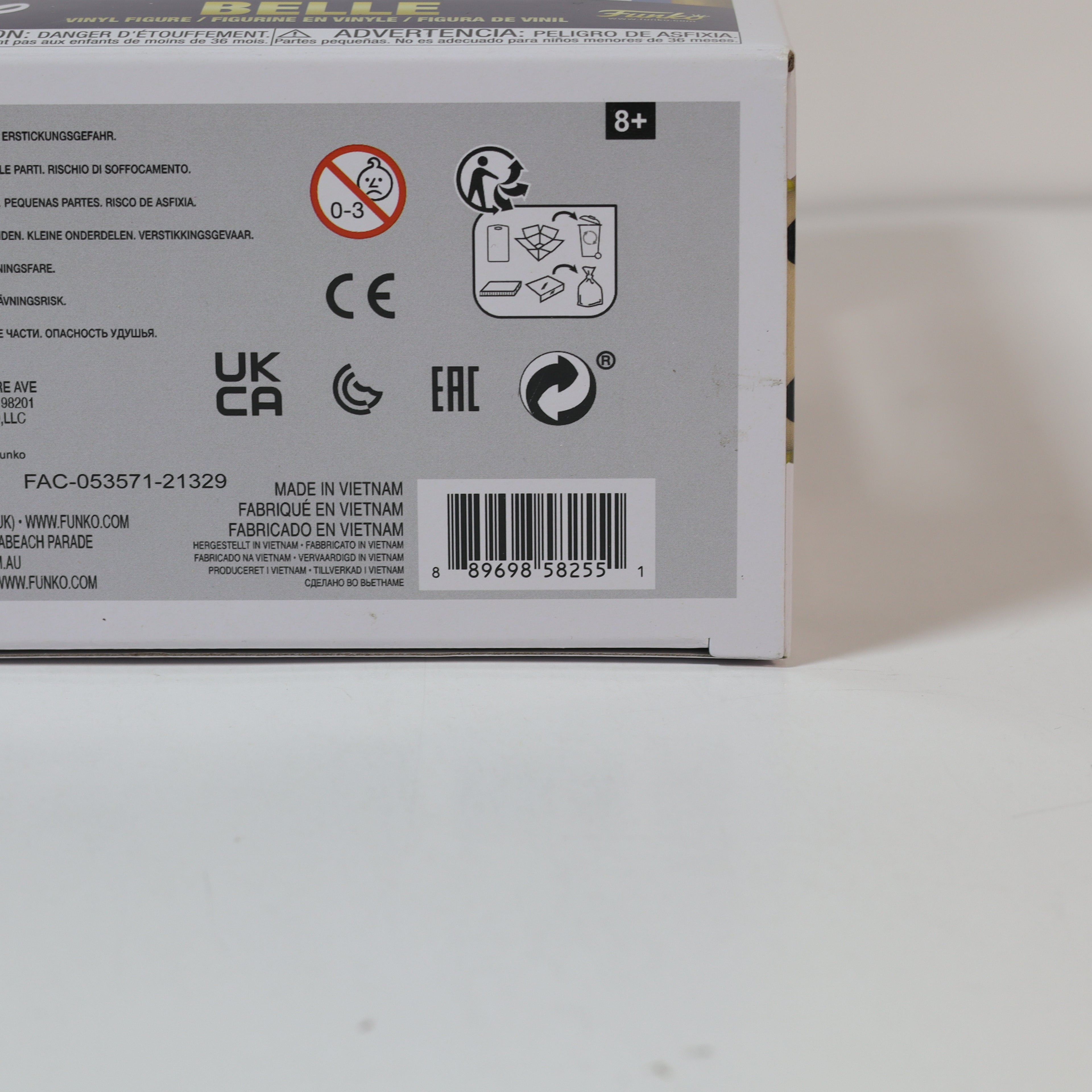 Back of a toy packaging box with various symbols and text on a light gray background