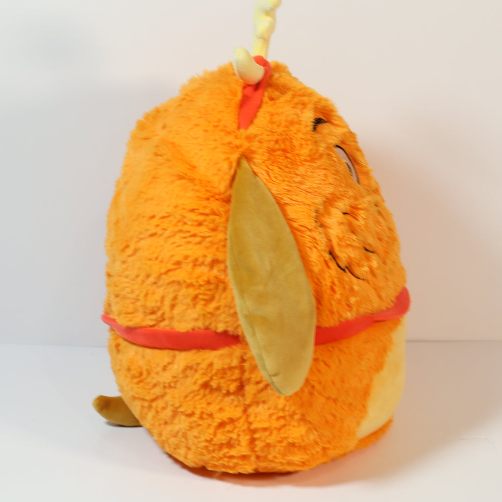 Plush toy resembling a cartoon character with an orange body and yellow ears on a white background