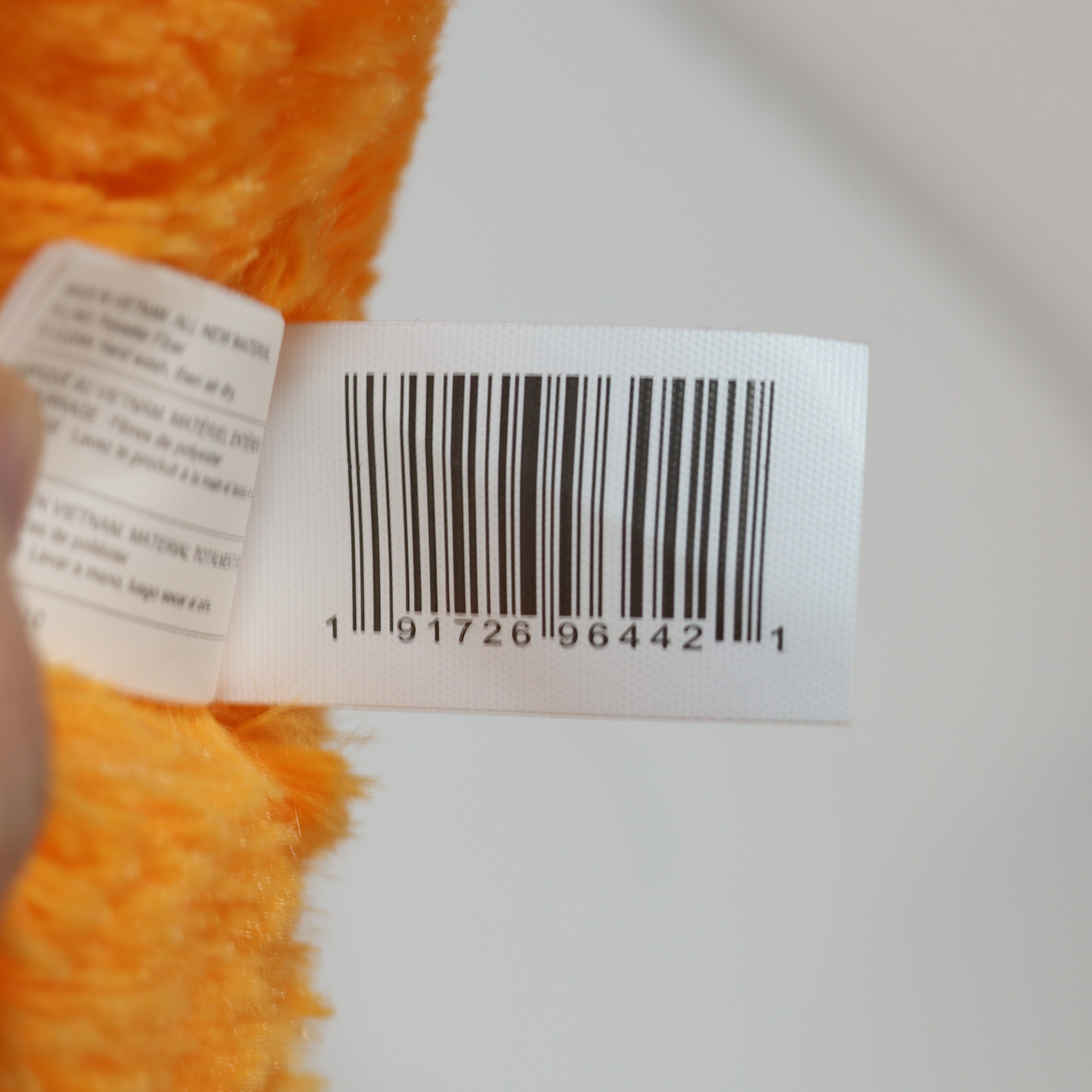 Close-up of a barcode label on a product with orange texture.