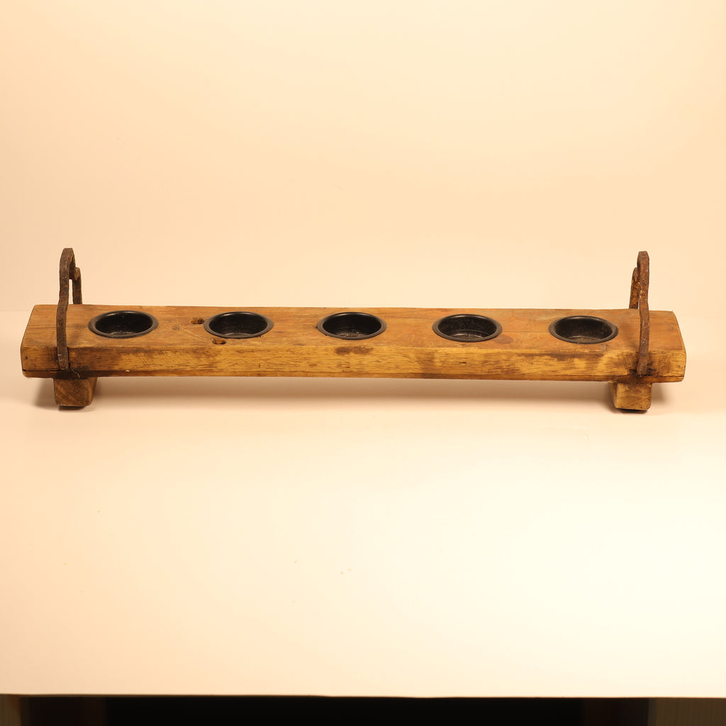 Wooden holder with five circular slots on a beige background