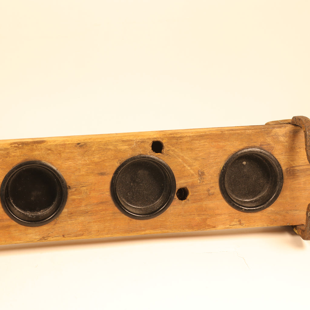 Wooden holder with three black cups on a beige background