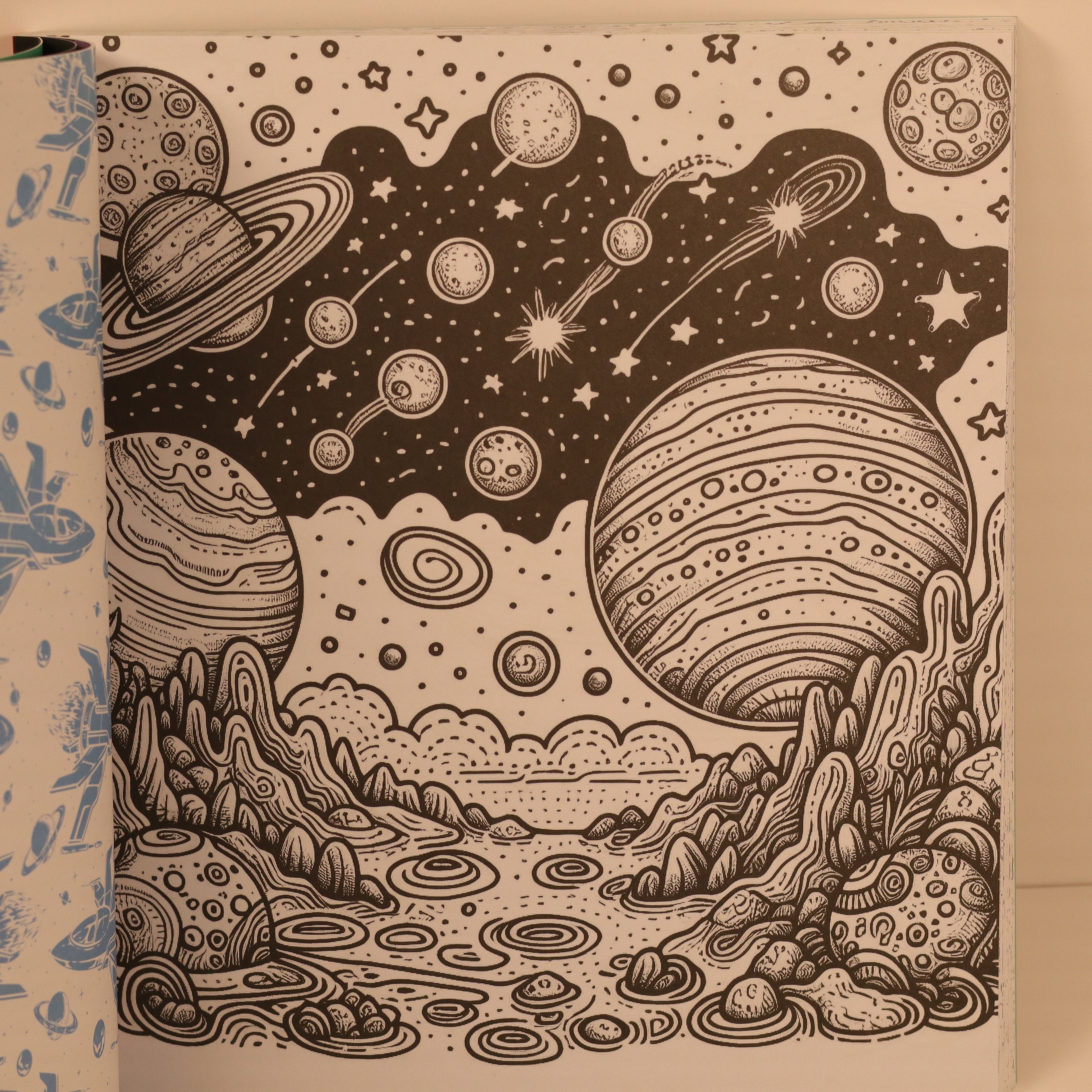 Illustration of a cosmic landscape with planets and stars on a notebook cover.