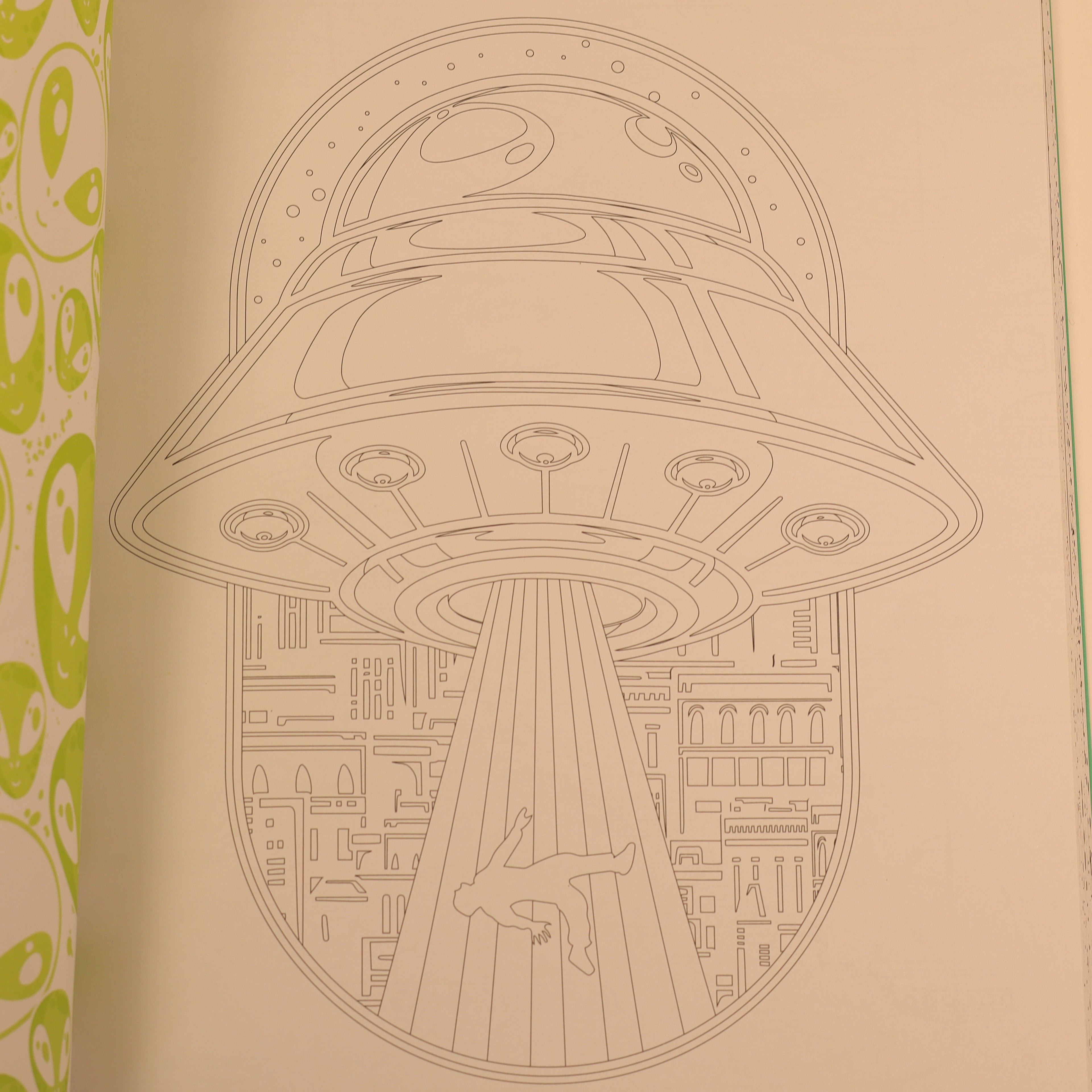 Illustration of a UFO hovering over a cityscape with a green patterned border.
