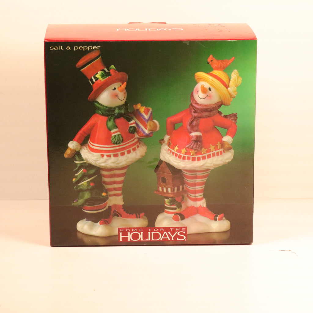 Decorative salt and pepper shakers in holiday attire with packaging labeled 'Home for the Holidays'.