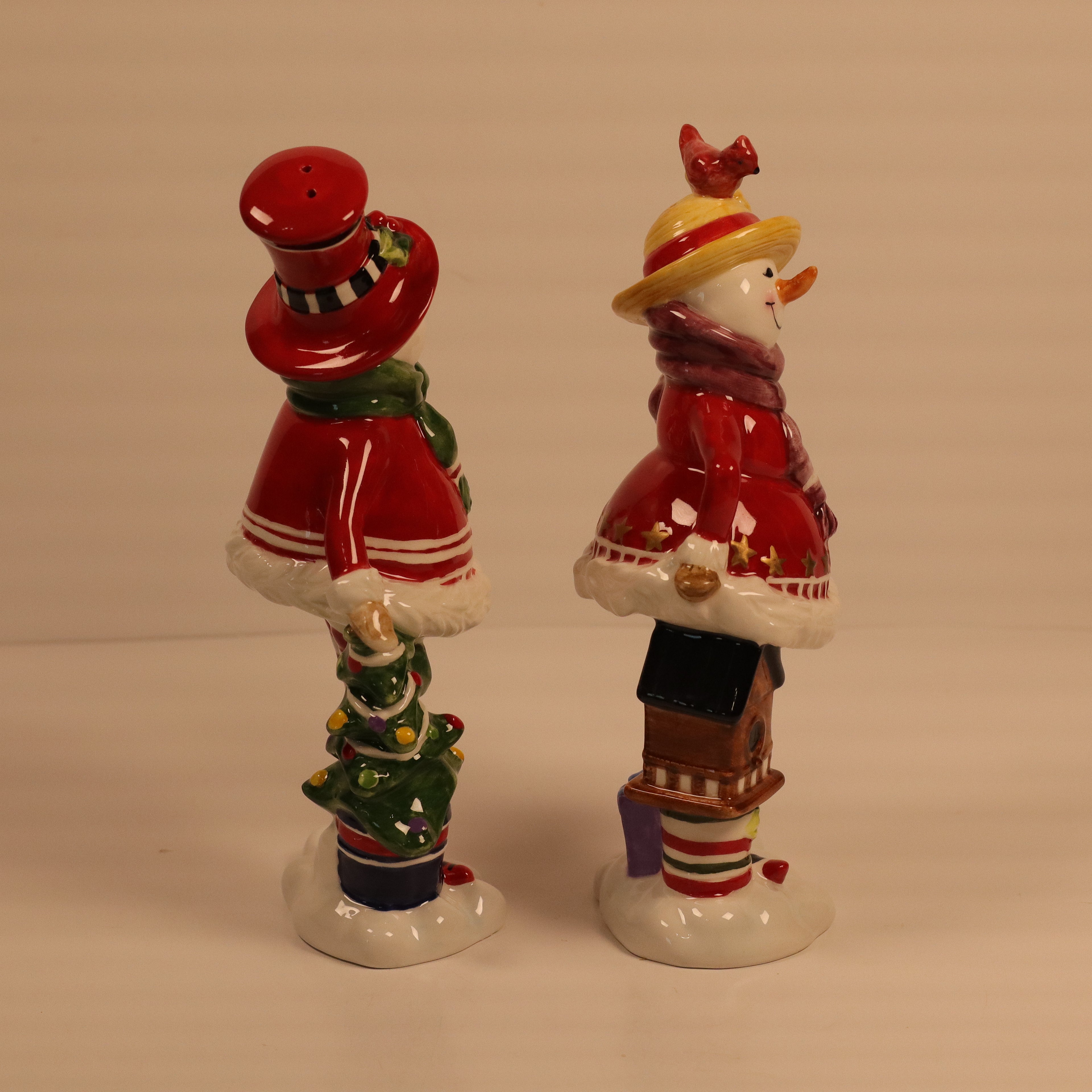 Two decorative figurines with colorful outfits on a plain background