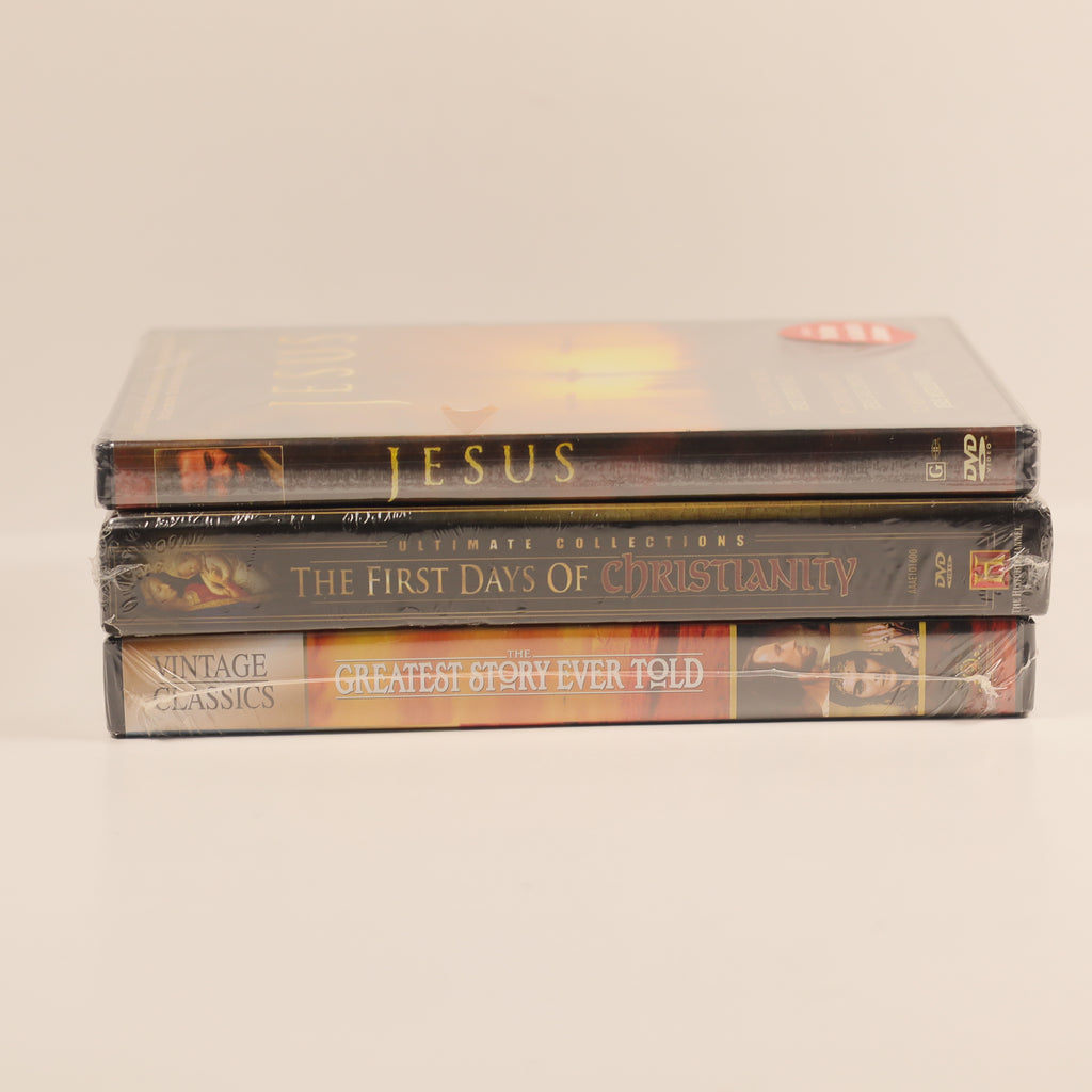 Stack of DVDs on a beige background. Jesus dvd, The first days of Christianity DVD, The greatest story ever told dvd.