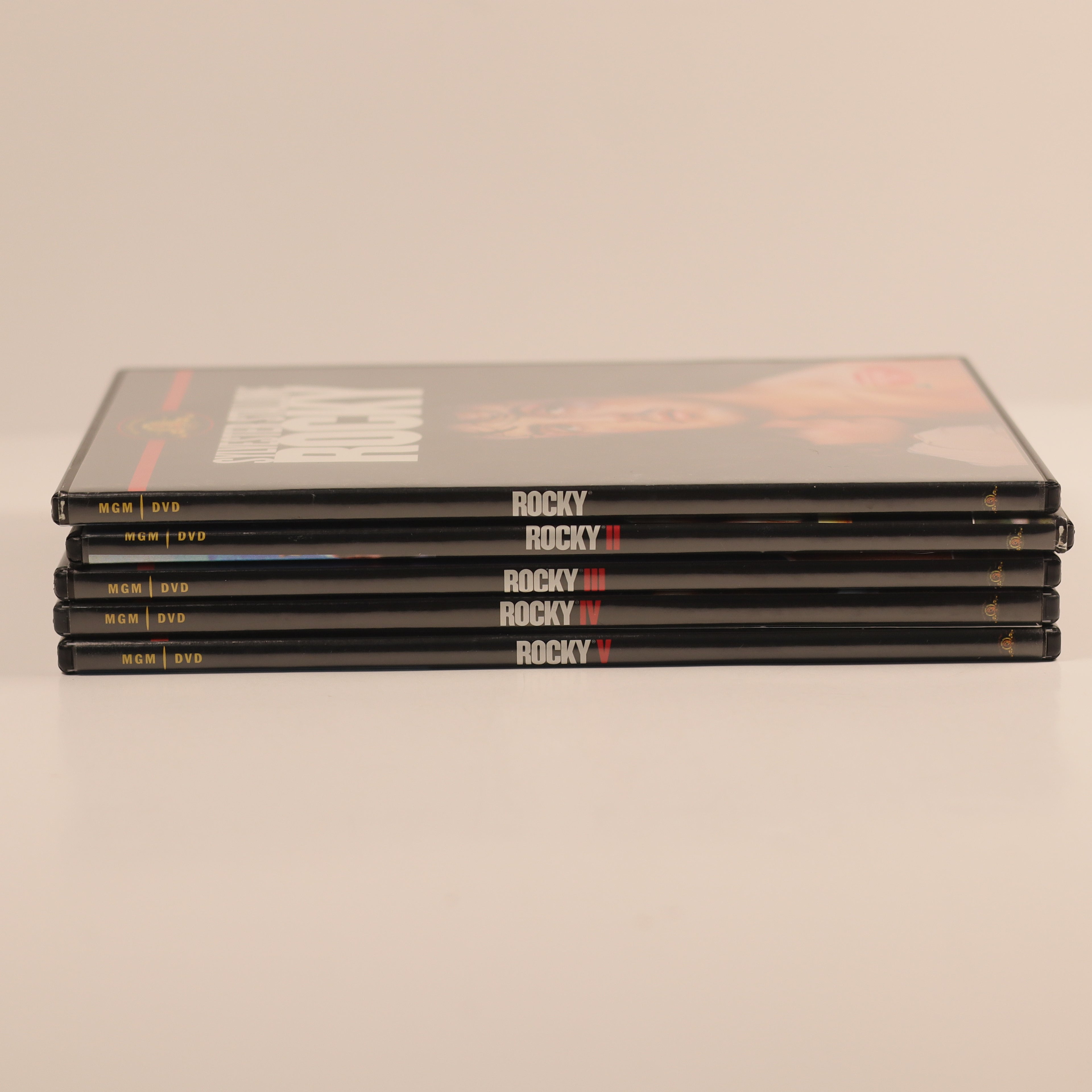 Stack of 'Rocky' movie DVD cases on a beige background