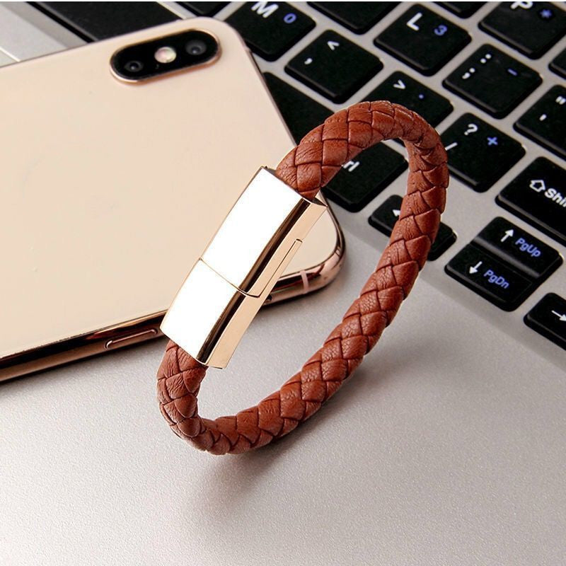 USB flash drive with braided brown leather strap on a laptop keyboard